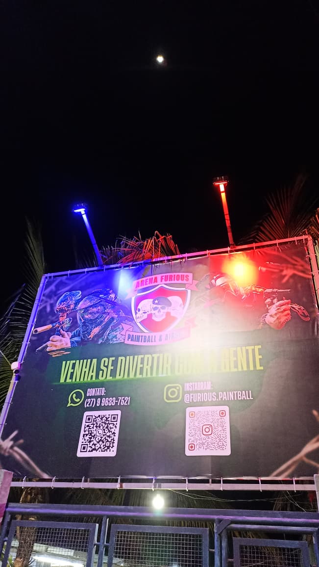 Fachada iluminada da Arena Furious com banner, portão e identificação visual